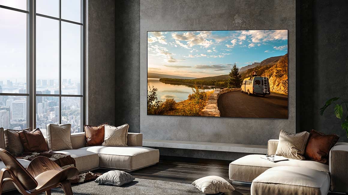 A 98 inch Supersize TV is mounted on a wall in a living room displaying nature.