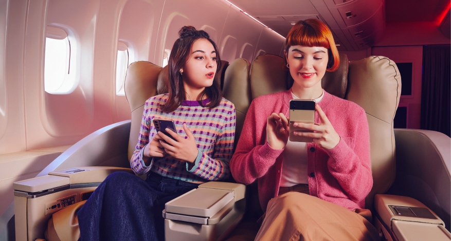 Dwie kobiety patrzące na ekran Samsung Galaxy Z Flip4. Jedna z nich jest zaskoczona a druga się uśmiecha 