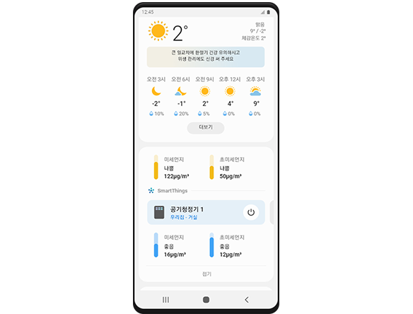 갤럭시 스마트폰에 날씨 앱이 떠 있습니다. 기온과 미세먼지 정도, 거실 공기청정기 가동 여부 등의 정보가 표시되어 있습니다.