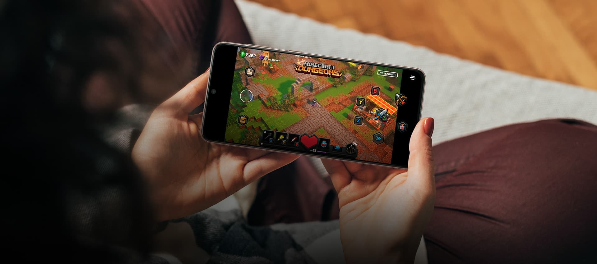 Una persona sostiene un Galaxy S21 con ambas manos. En la pantalla hay un juego móvil.