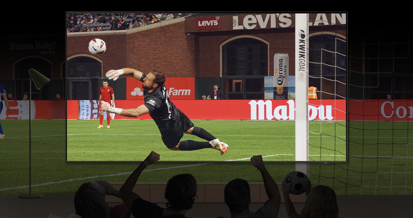 Los fanáticos de los deportes ven un partido de fútbol en un televisor Samsung Super Large.