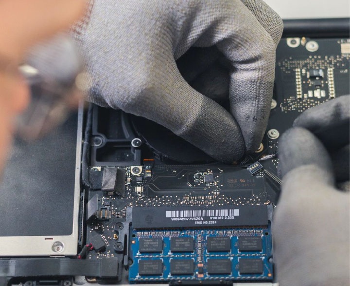A zoomed in shot of a Samsung chip is shown. Gloved hands fix the inside