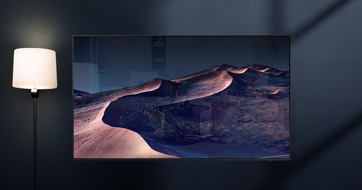 A TV displays a scene of a desert in a starry night. A nearby lamp throws distracting reflections on the screen. With glare-free technology, the screen becomes clear. No discomfort, disability, reflection icons. UL Verified Logo. Glare Free: Reflection Glare UGR  10, Discomfort Glare  UGR 22, Disability Glare  34. verifyUL.com®. V166045.
