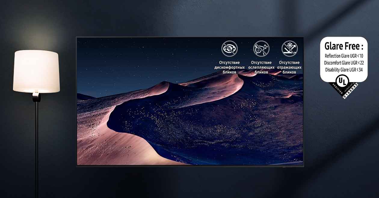 A TV displays a scene of a desert in a starry night. A nearby lamp throws distracting reflections on the screen. With glare-free technology, the screen becomes clear. No discomfort, disability, reflection icons. UL Verified Logo. Glare Free: Reflection Glare UGR  10, Discomfort Glare  UGR 22, Disability Glare  34. verifyUL.com®. V166045..