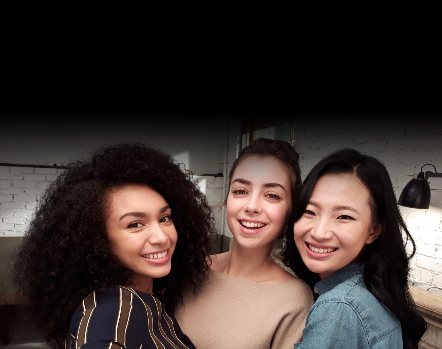 Galaxy A5 (2017)'nin gelişmiş kamera işlevselliğini göstermek için düşük ışık altında üç kadının Selfie görüntüsü.