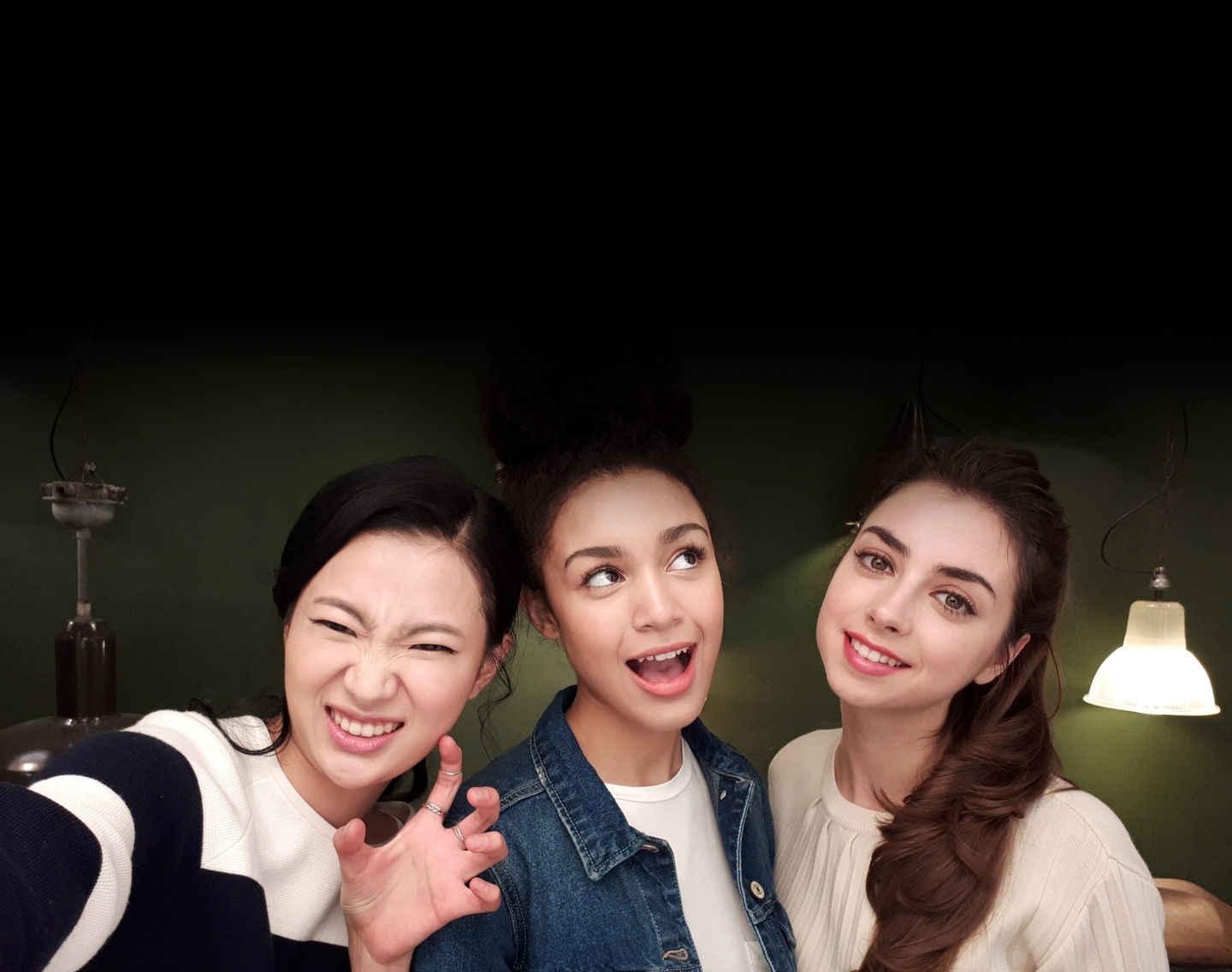 Galaxy A7 (2017)'nin gelişmiş kamera işlevselliğini göstermek için düşük ışık altında üç kadının Selfie görüntüsü.